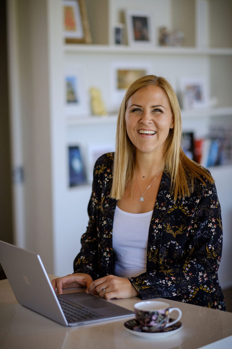 Talent acquisition specialist sitting smiling in front of laptop.